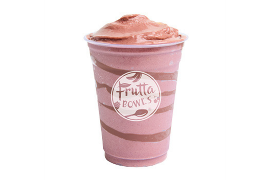 A thick, creamy pink smoothie served in a clear plastic cup with chocolate swirls and the Frutta Bowls logo printed on the front.