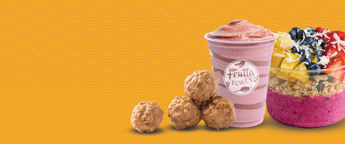 Energy bites, a pink smoothie, and a colorful fruit bowl with granola, set against a yellow patterned background.