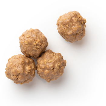 Four round peanut butter oatmeal energy bites on a white surface.