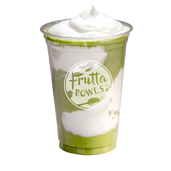 Clear plastic cup with a layered green and white drink topped with whipped cream and Frutta Bowls logo on a light gray background.