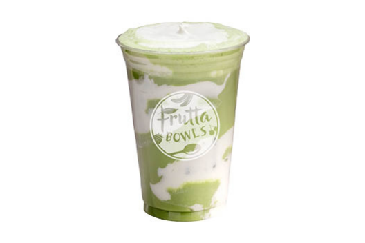 Clear plastic cup with a layered green and white drink, topped with cream, with Frutta Bowls logo on a light gray background.